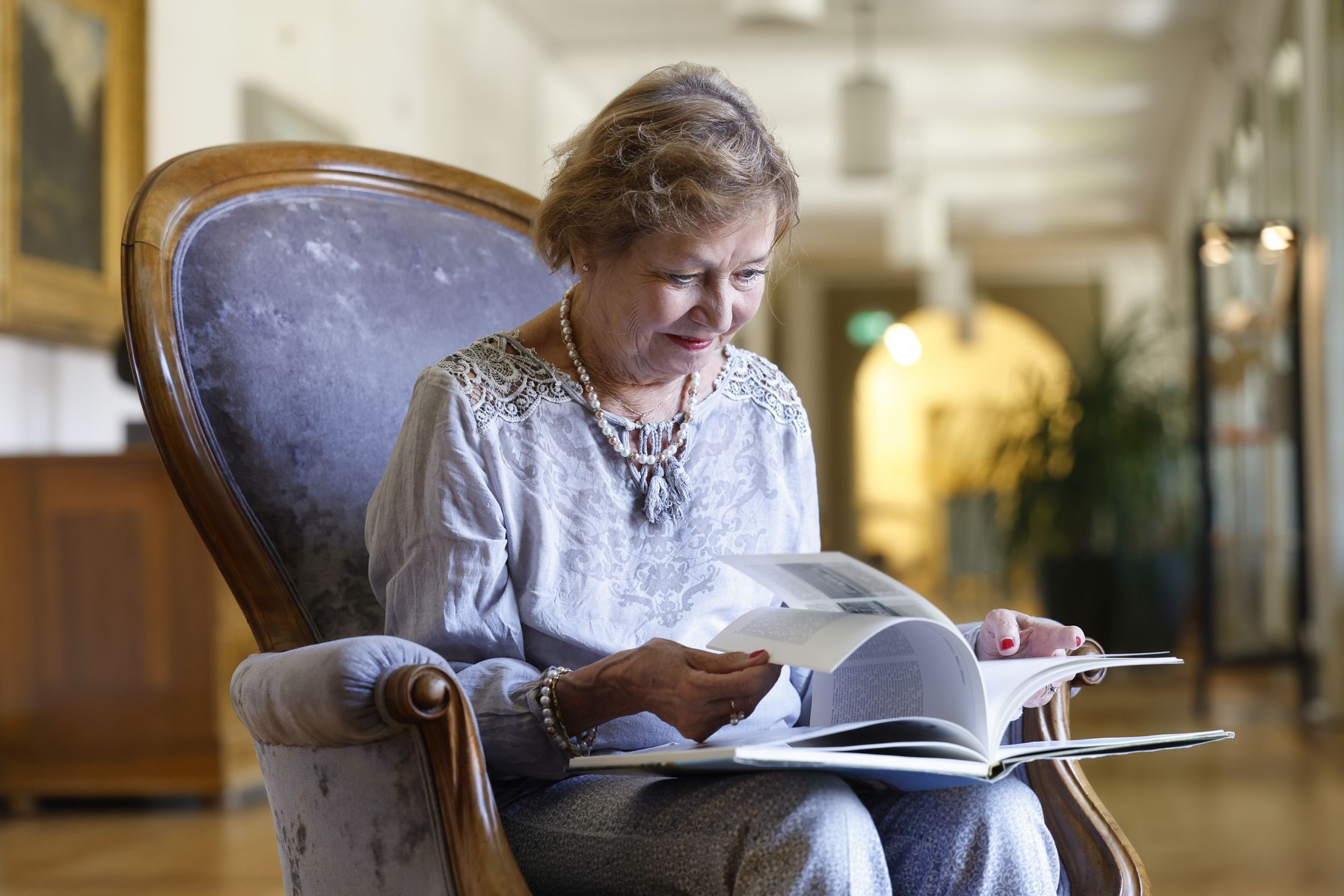 Eine Bewohnerin am Lesen im Sessel