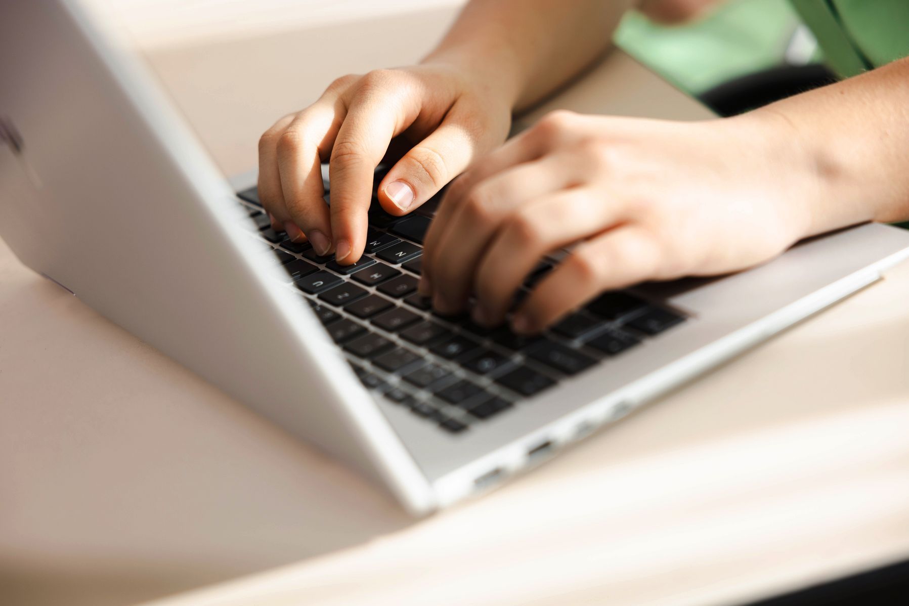 Junge Person schreibt am Laptop