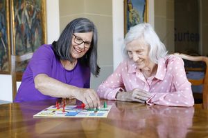 Eine Freiwillige spielt mit einer Bewohnerin 
