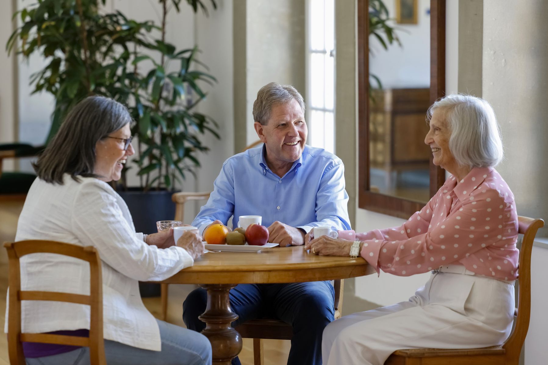 3 Personen am runden Tisch am sitzen
