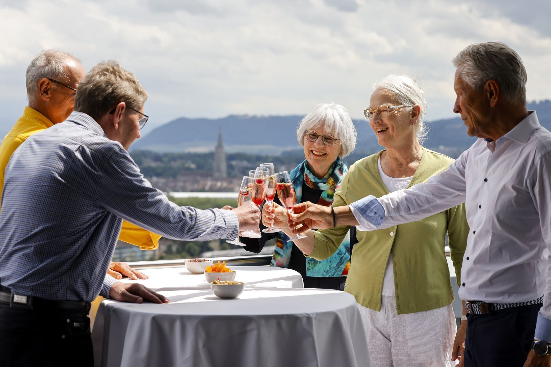 Anstossen mit Sektgläsern auf Dachterrasse